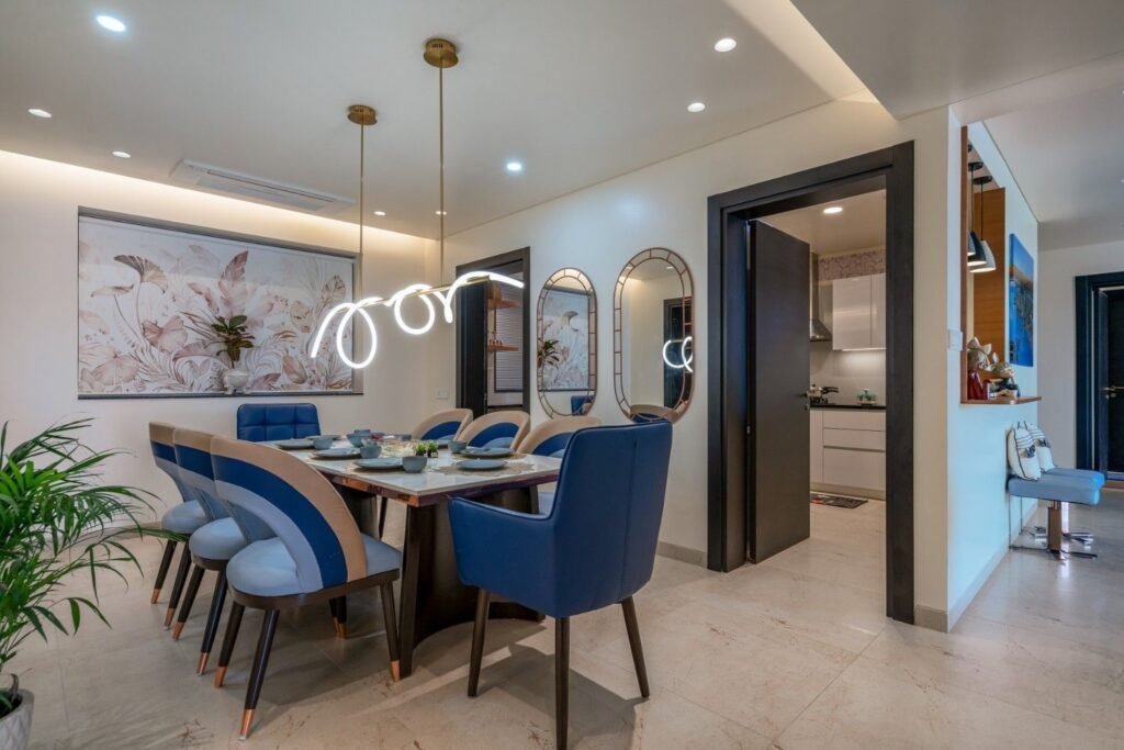 Modern dining room interior by residential interior designer in Pune with designer lighting and luxury seating